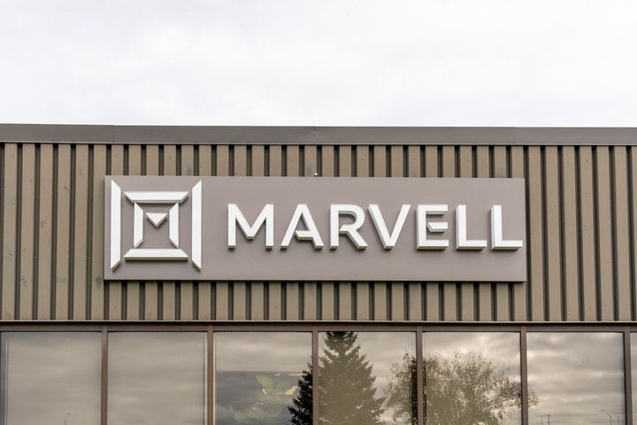 "Signage displaying the name 'MARVELL' in bold, modern letters, mounted on a textured gray panel above reflective windows."