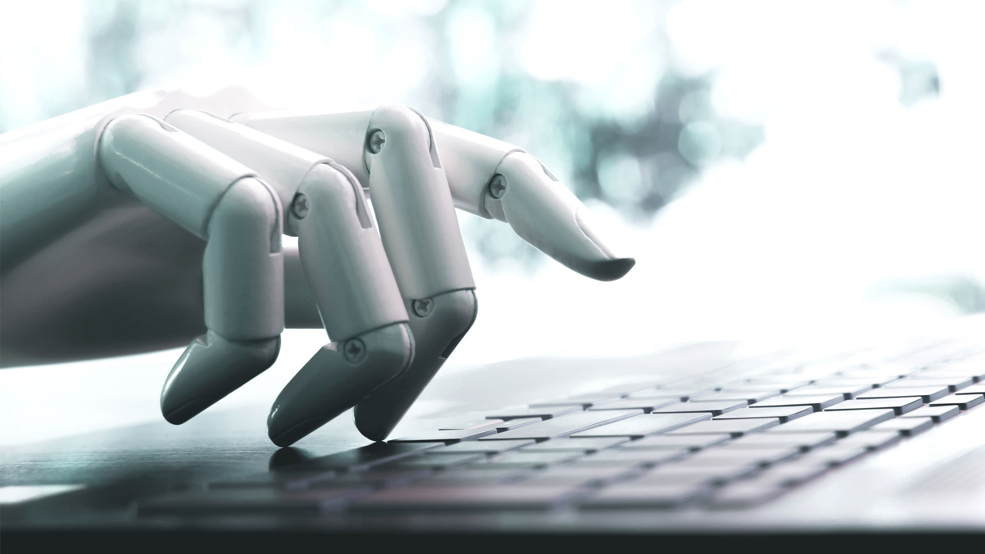 "Robotic hand reaching towards a keyboard."